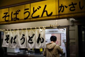 A photo of a traditional Japanese Izakaya with its signature design style with the use of banners.