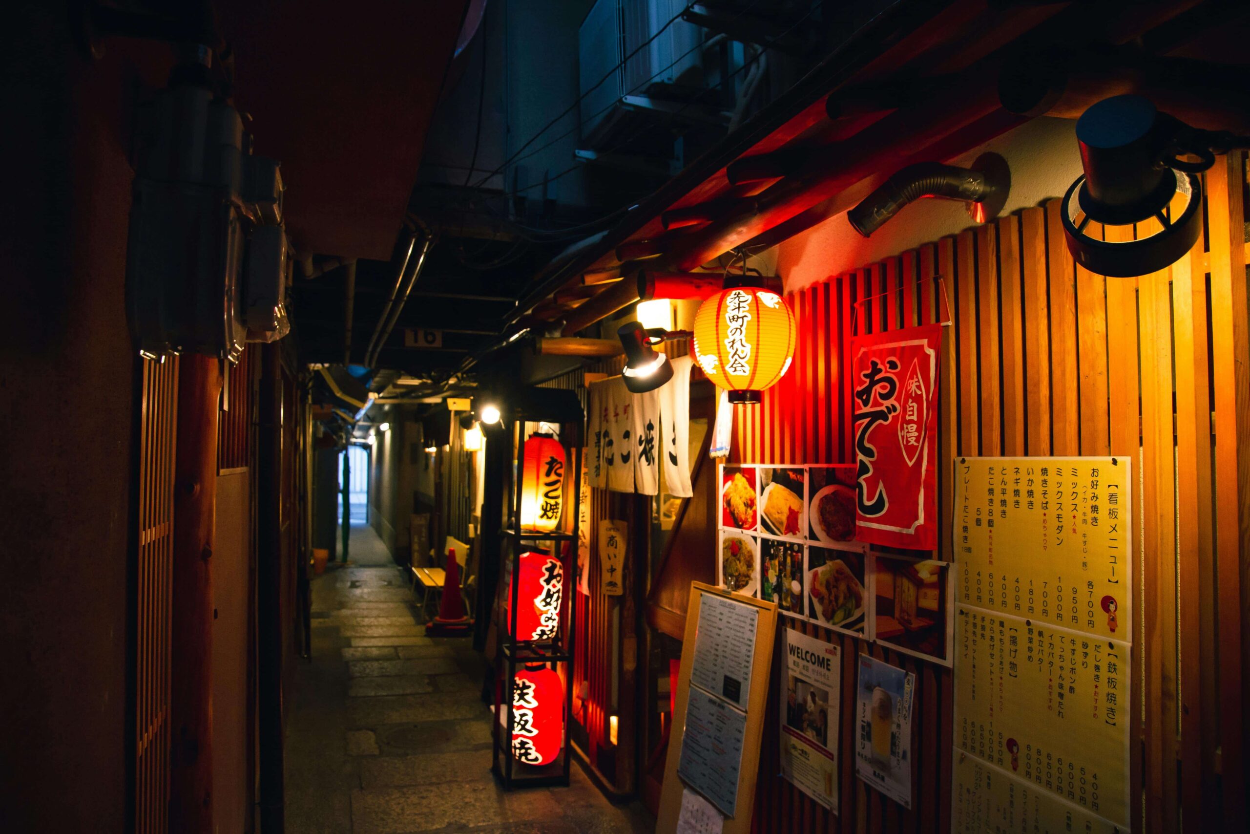 A night shot of an Izakaya illuminated by its own lanterns.