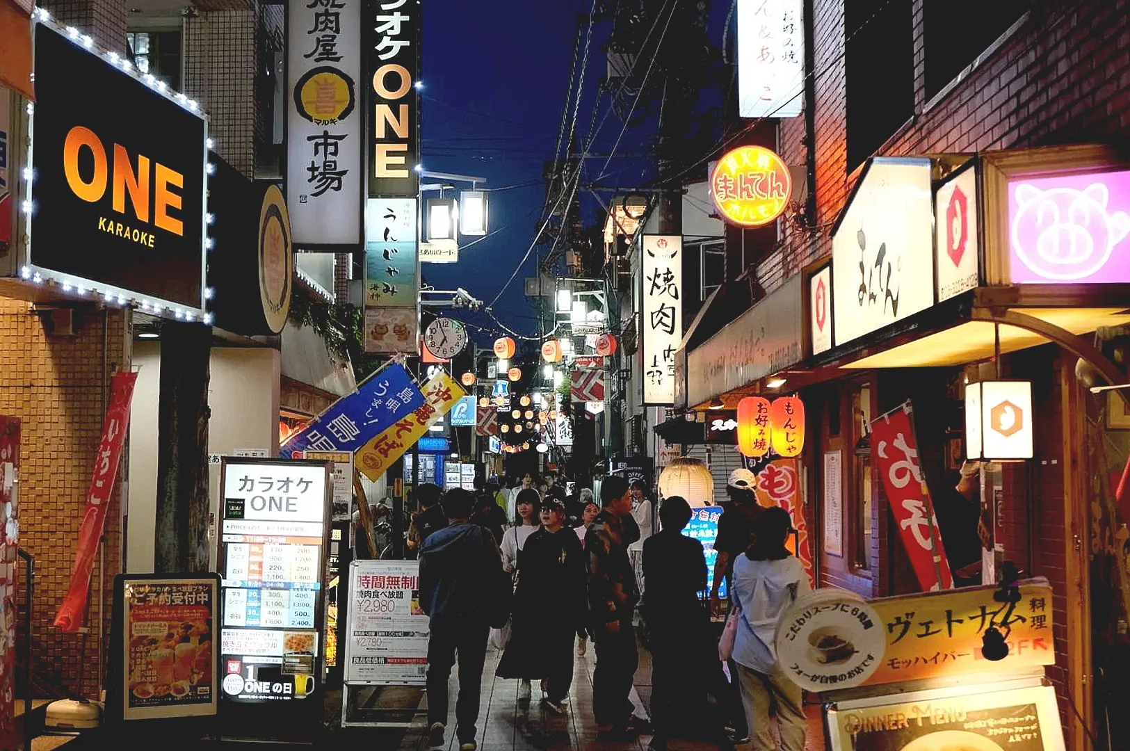 Busy nightlife street near Nakano Broadway with izakaya signs and restaurants.