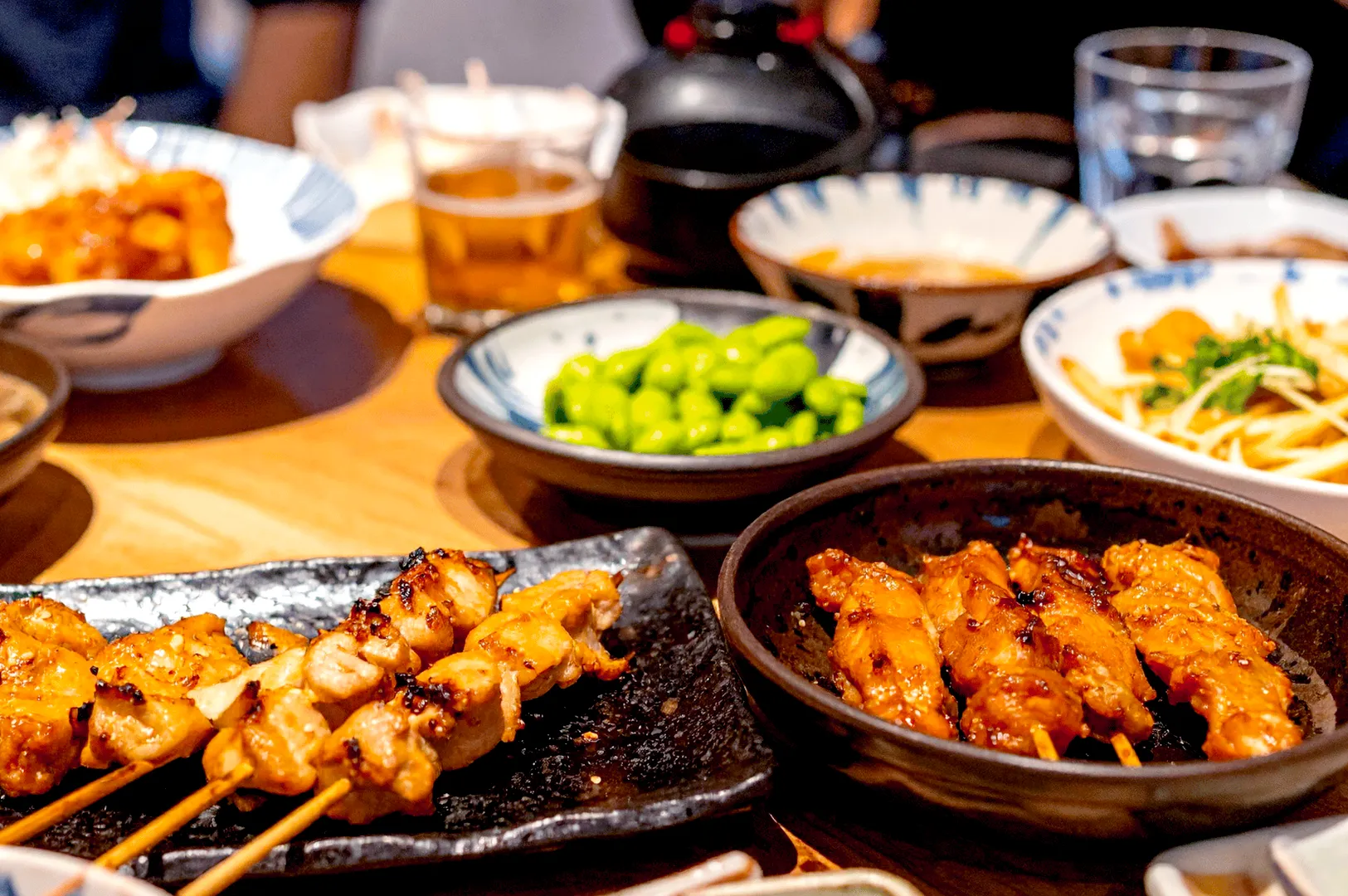 Japanese izakaya spread with yakitori and side dishes