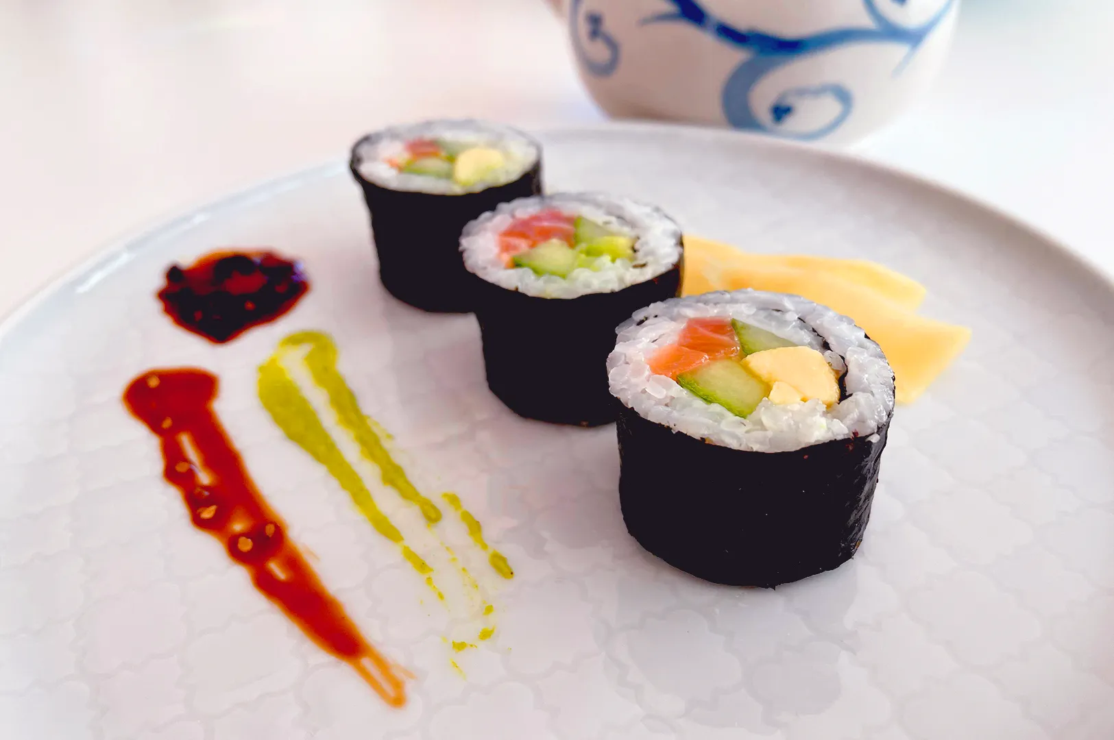 Fresh sushi rolls plated with sauces and garnish