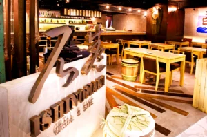 Modern izakaya interior at Ishinomaki Grill & Sake Singapore with wooden tables, sake barrels, and warm ambient lighting near Orchard Road