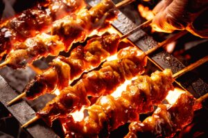 yakitori skewers grilling over charcoal fire in Singapore izakaya, showcasing timing and heat control for perfect texture and flavor