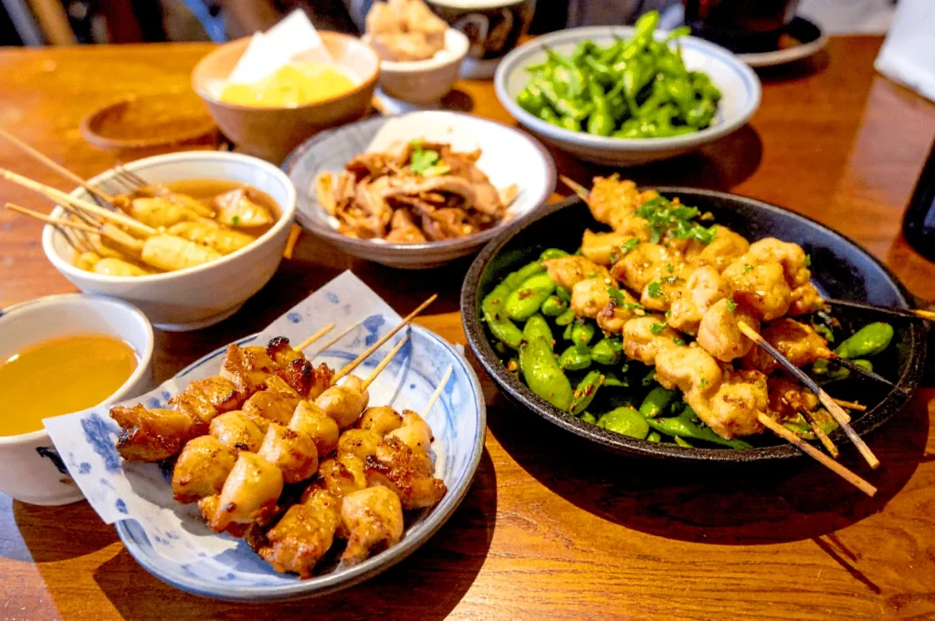 Kukai Izakaya Singapore table spread with yakitori skewers, edamame, and Japanese small plates in Orchard dining area