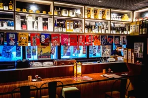 Japanese izakaya bar interior with sake bottles and counter seating, warm lighting dining atmosphere Singapore