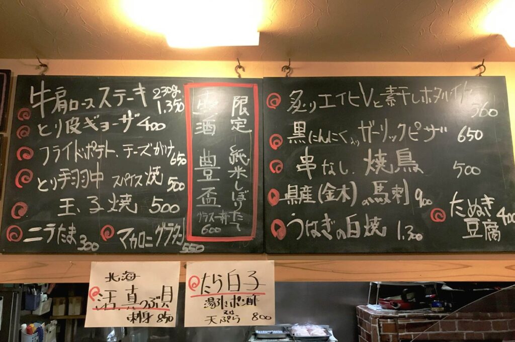 Japanese izakaya chalkboard menu with handwritten specials and limited items showing sold out and seasonal dishes