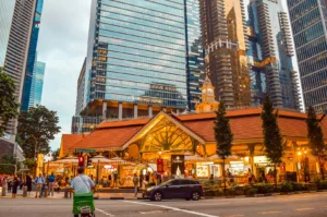 Exterior of the historic Lau Pa Sat market structure in Singapore, with modern skyscrapers in the background.