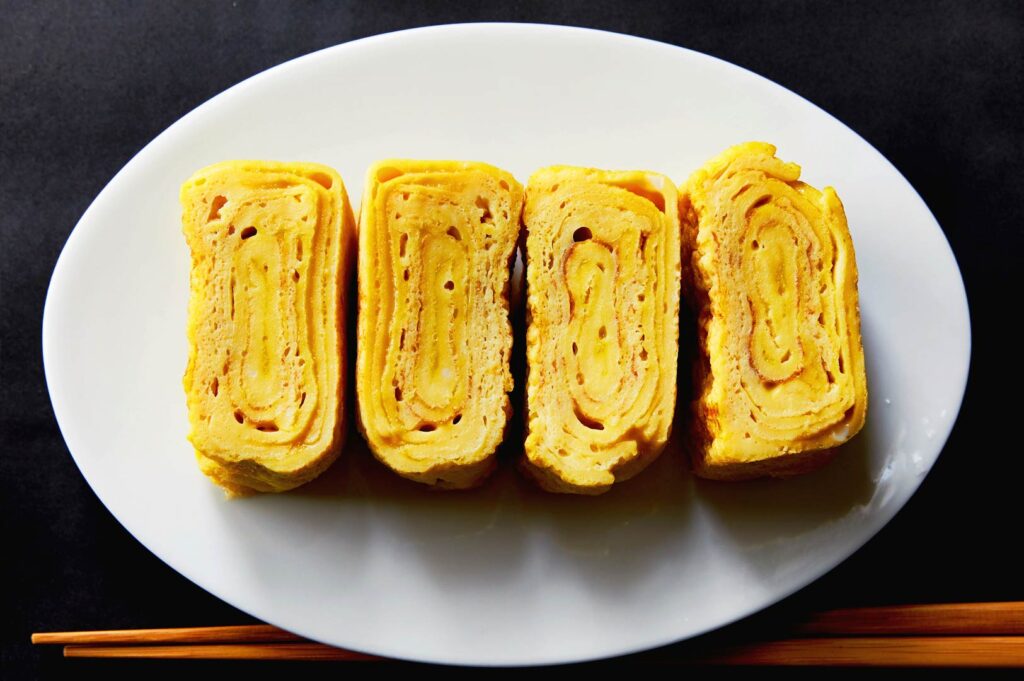 perfect layered tamagoyaki Japanese rolled omelette plated in izakaya style close up
