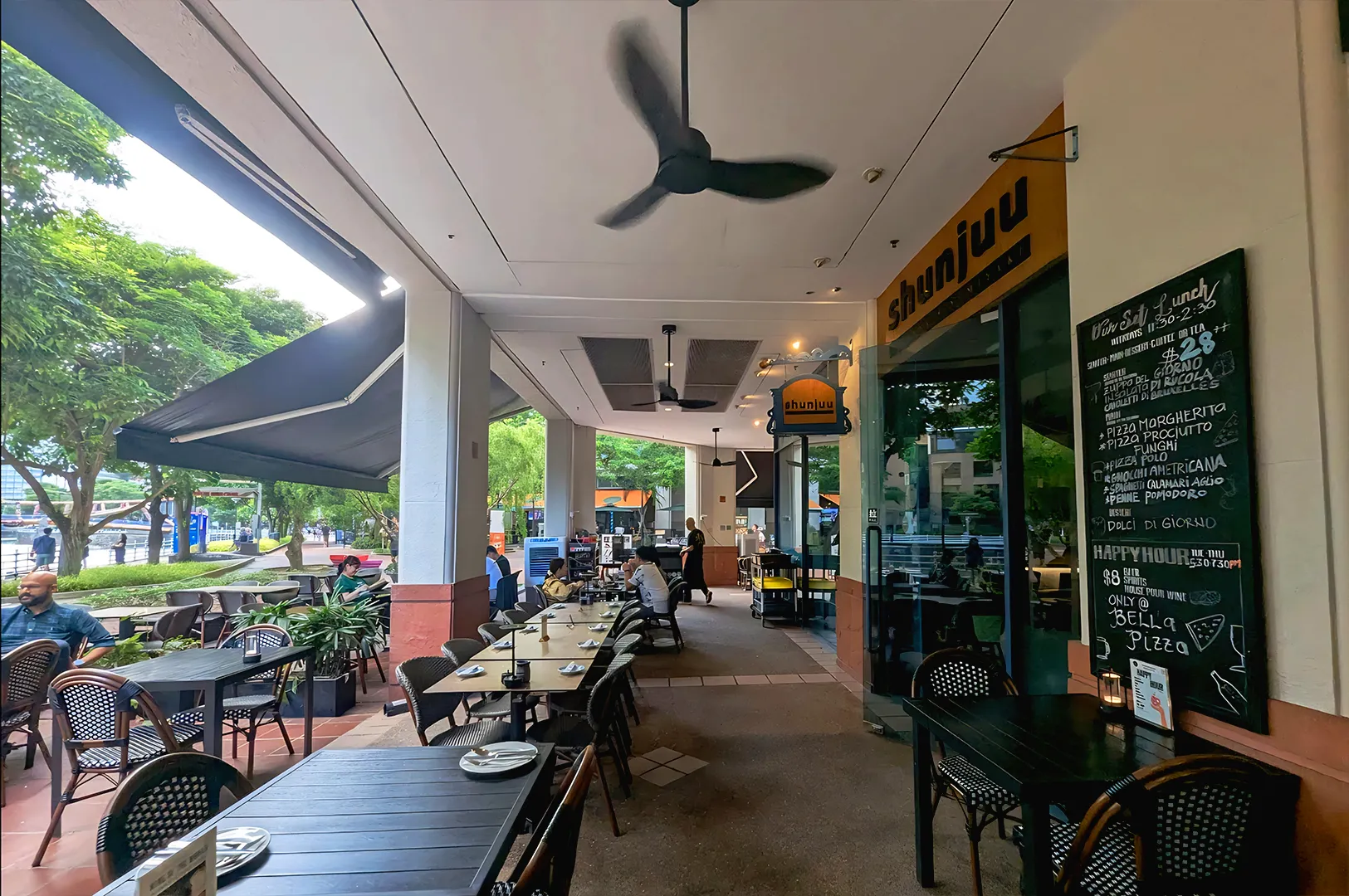 Outdoor restaurant seating area in Singapore with casual dining tables, covered walkway, and relaxed urban café atmosphere
