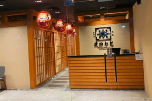 Entrance of Izakaya Matsumoto with wooden counter and shoji screens.
