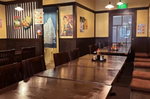 Empty Japanese restaurant dining room with wooden tables and chairs.