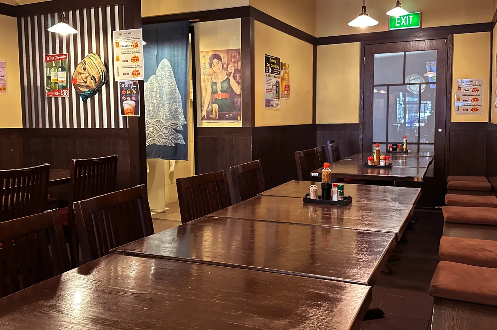 Empty Japanese restaurant dining room with wooden tables and chairs.