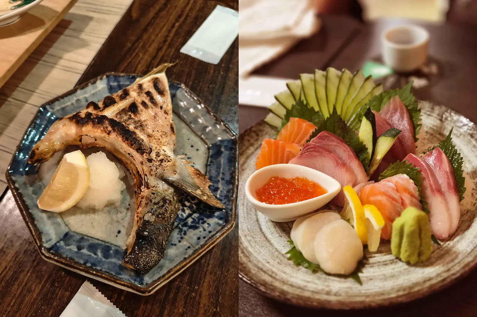 Grilled fish and sashimi served on ceramic plates on a wooden table.