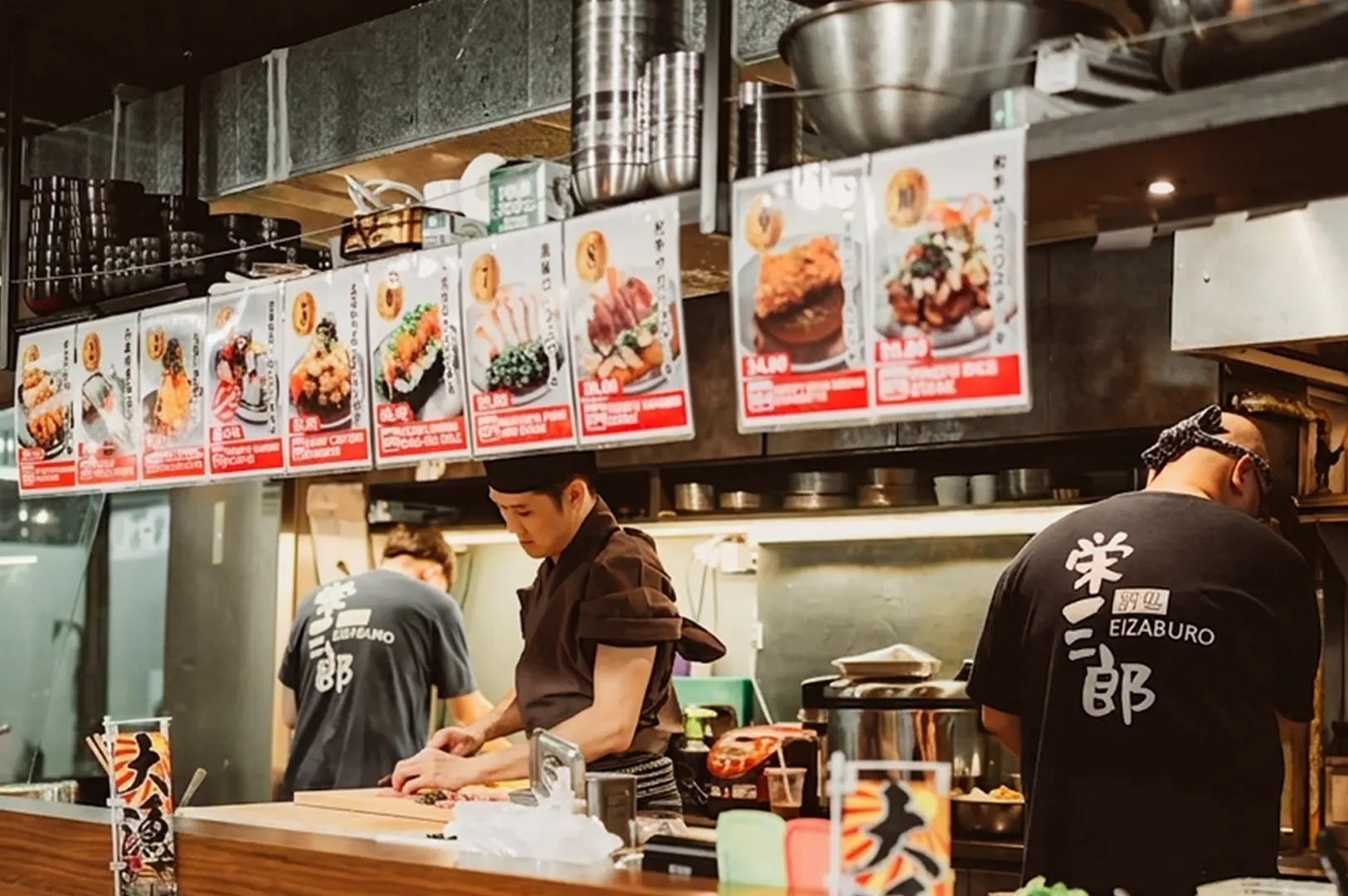Kitchen staff at counter with menu boards