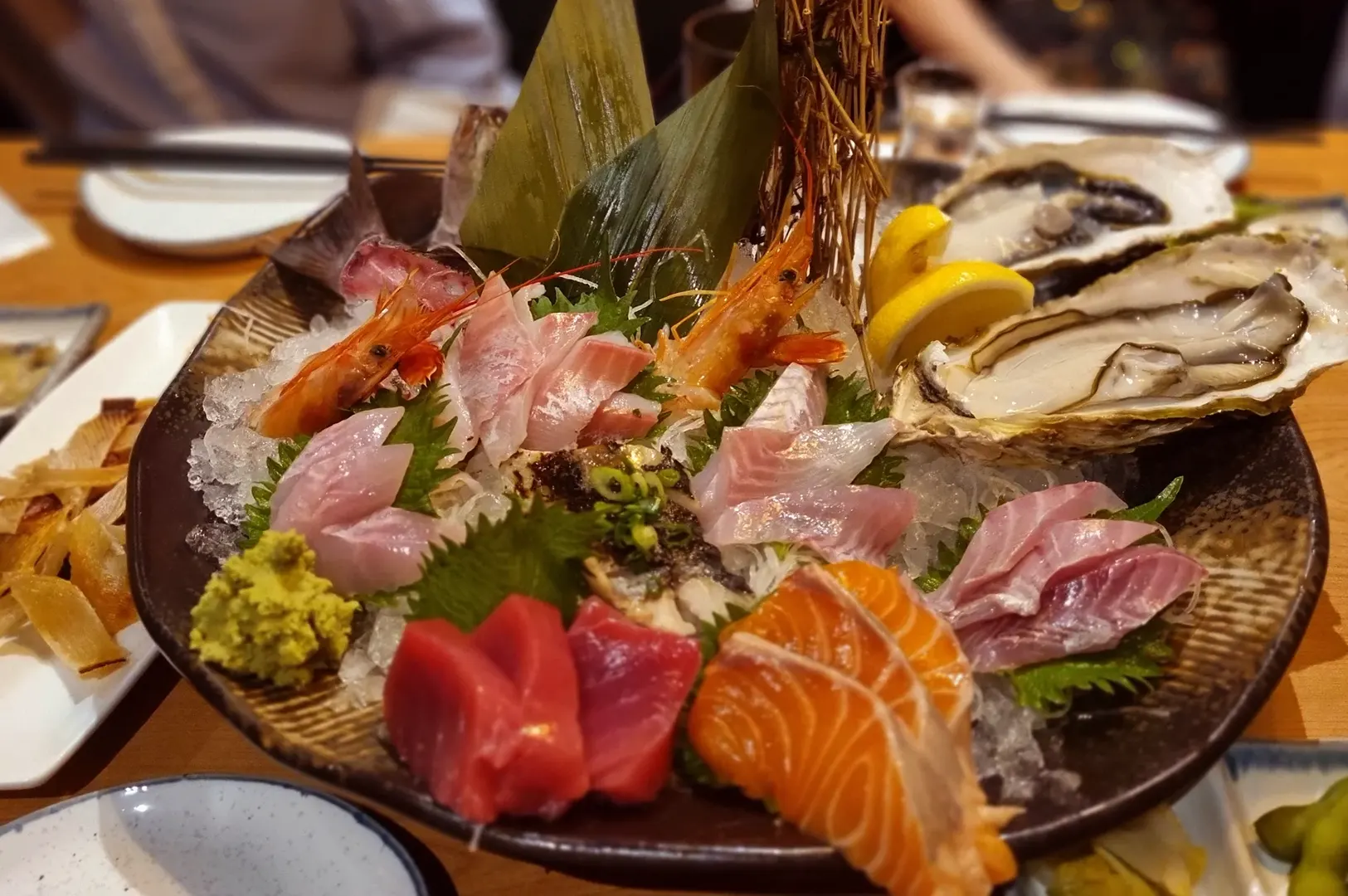 Sashimi and oyster platter with tuna, salmon, and prawns.