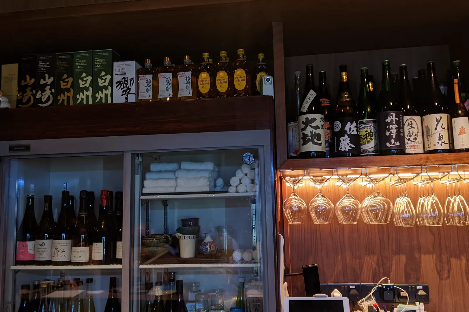 Sake bottles and glassware display at HEARTH Irori & Oden Izakaya.