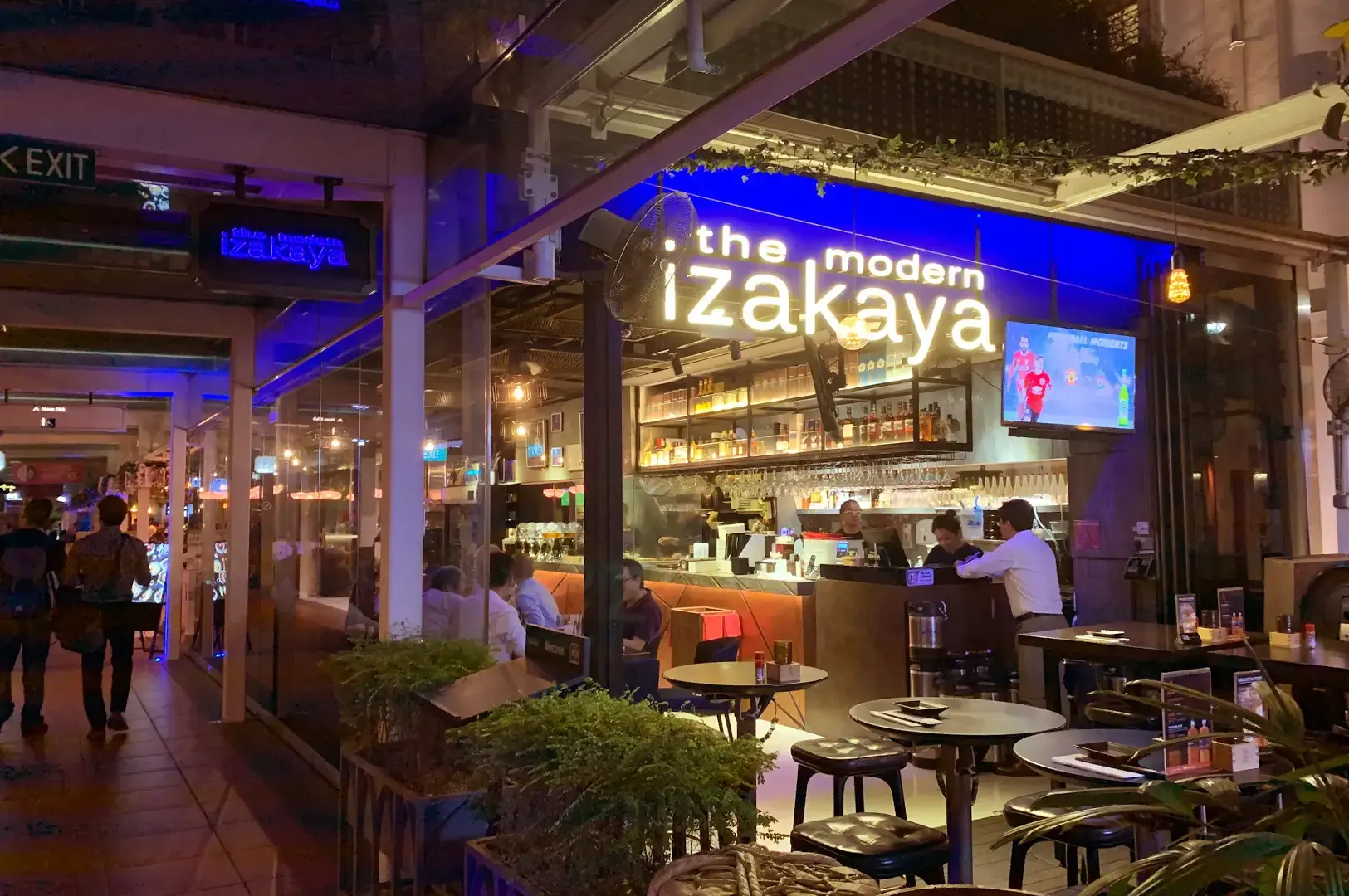 The Modern Izakaya exterior at night with outdoor seating.