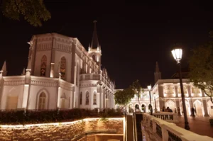 CHIJMES white Gothic chapel illuminated at night with courtyard and street lamp