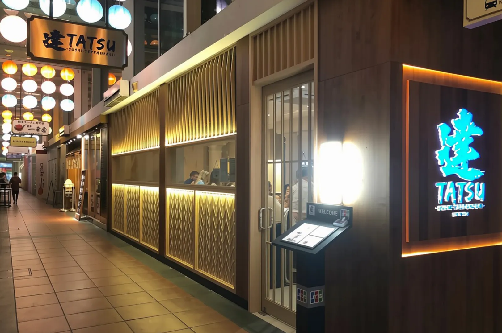 Tatsu restaurant exterior at Chijmes with glowing blue sign and lit entrance.